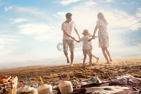 幸福的一家四口在沙滩上做游戏图片