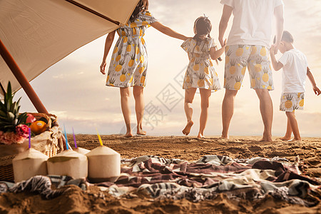 沙滩毯子幸福的一家四口在沙滩上散步背景