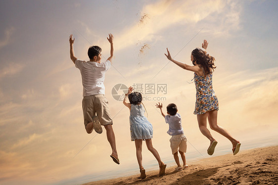 沙滩上跳跃的快乐四口之家背影图片