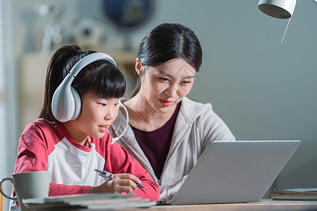 年轻妈妈辅导女儿上网课图片