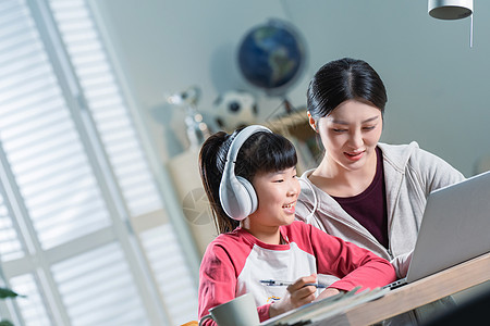 年轻妈妈辅导女儿上网课图片