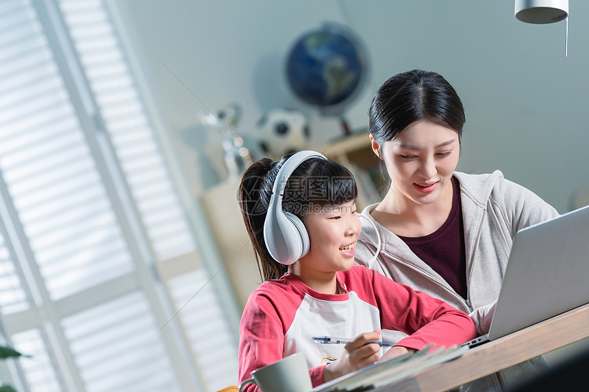 年轻妈妈辅导女儿上网课图片