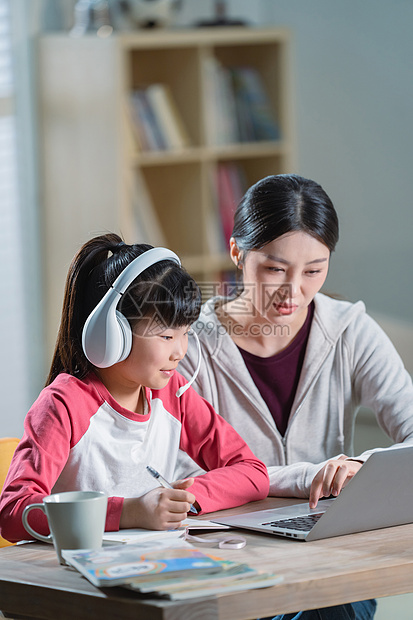 年轻妈妈辅导女儿上网课图片