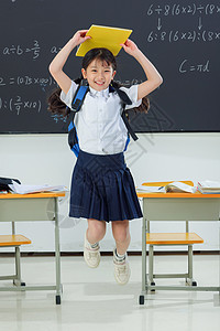 快乐的小学女生在教室里欢呼跳跃图片