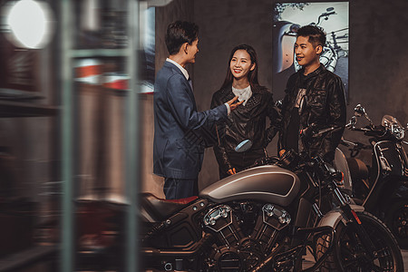 摩托车销售人员为青年伴侣介绍图片