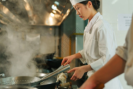 后厨内的专业厨师团队烹饪美味佳肴高清图片