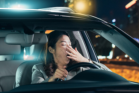 疲劳的青年女人驾驶汽车高清图片