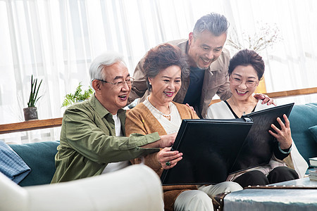 快乐的中老年夫妇一起看相册高清图片下载-正版图片507638477-摄图网