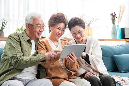 快乐的老年人一起看平板电脑图片