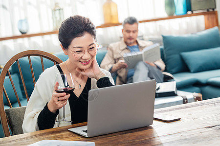 红科技优雅的中老年人在家使用电脑背景
