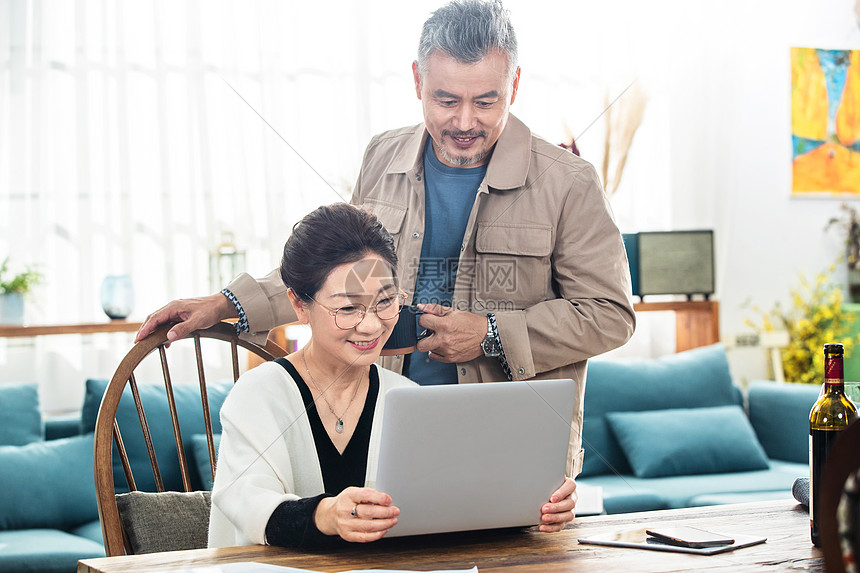 幸福的中老年夫妇在家使用笔记本电脑图片