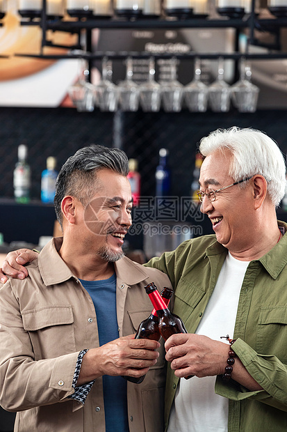 快乐的中老年男士拿瓶装啤酒干杯庆祝图片