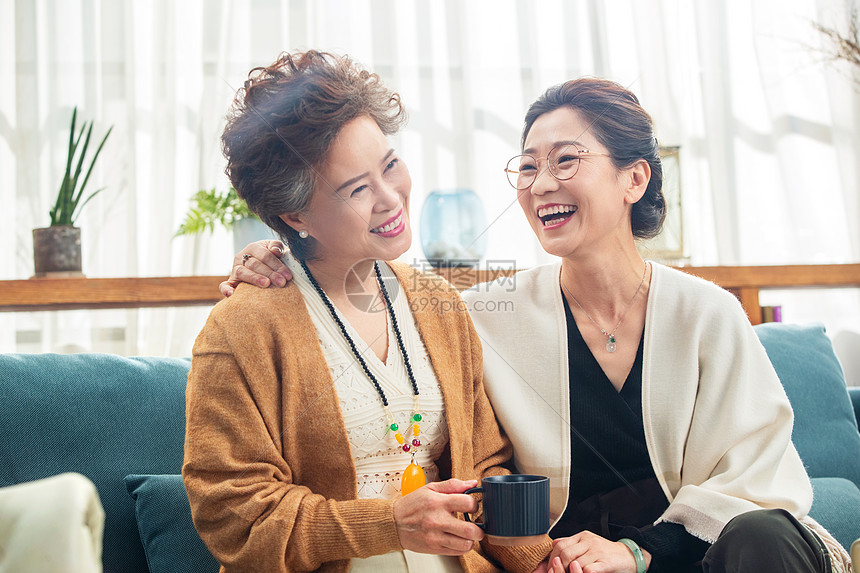 快乐的中老年闺蜜坐在沙发上聊天高清图片下载-正版图片507638766-摄图网