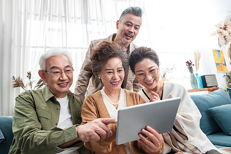 快乐的中老年人一起看平板电脑图片