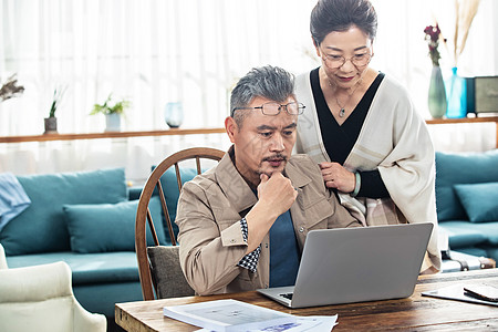 严肃的中老年夫妻俩盯着笔记本电脑图片