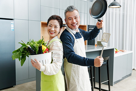 平底锅铲子中老年夫妇在厨房做饭背景