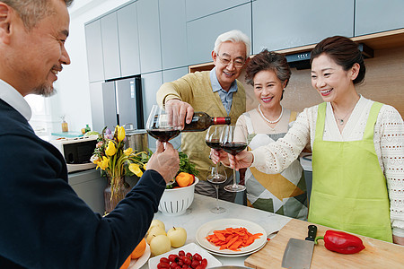 快乐的中老年人在厨房举杯庆祝图片