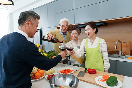 快乐的中老年人在厨房举杯庆祝高清图片