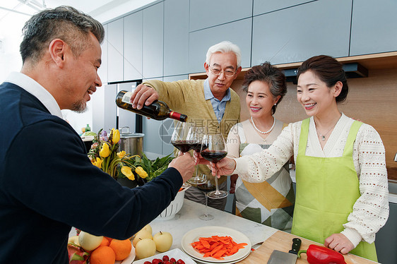 快乐的中老年人在厨房举杯庆祝图片