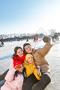 快乐的一家四口坐在溜冰场玩耍图片