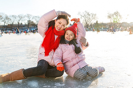 年轻妈妈和孩子在滑冰场玩耍图片