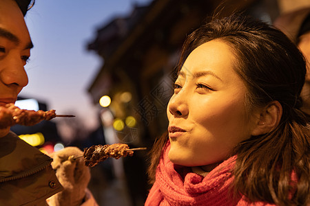 青年夫妇逛街吃羊肉串图片