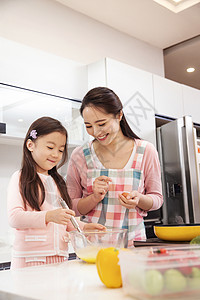 做饭的妈妈年轻妈妈和女儿在厨房背景