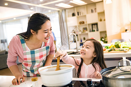 年轻妈妈和女儿在厨房背景