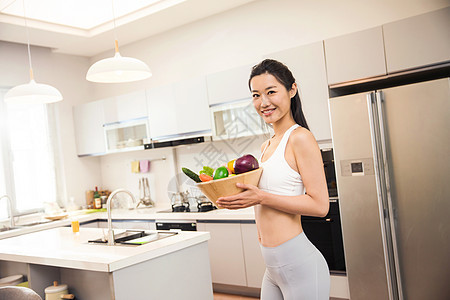 穿着运动装的青年女人在厨房图片