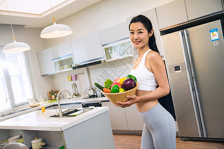 穿着运动装的青年女人在厨房图片