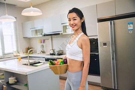 穿着运动装的青年女人在厨房图片