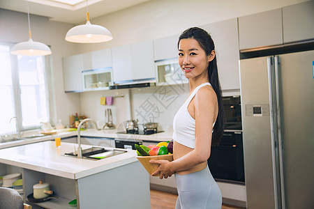 穿着运动装的青年女人在厨房图片