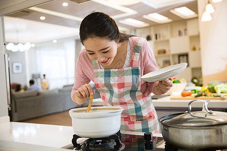 青年女人在厨房煲汤图片