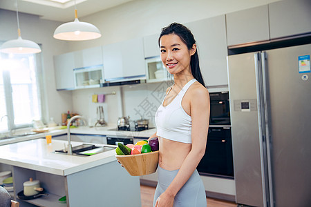 穿着运动装的青年女人在厨房图片