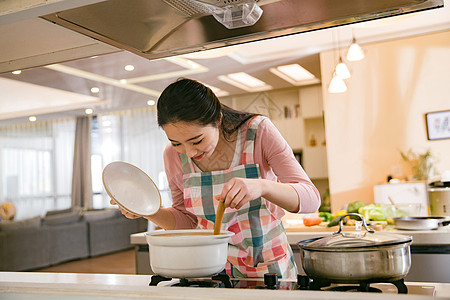 劳动妇女青年女人在厨房煲汤背景