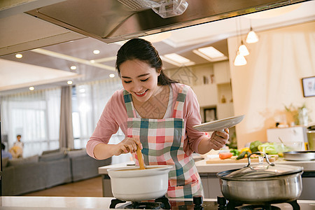 青年女人在厨房煲汤图片