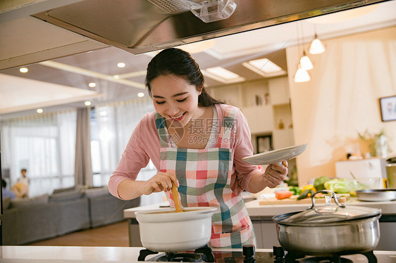 青年女人在厨房煲汤图片