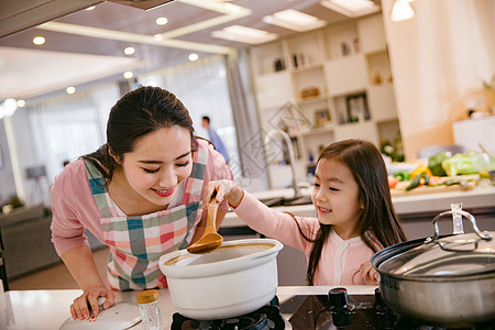 煮饭煲汤年轻妈妈和女儿在厨房背景