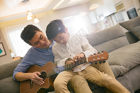 父亲和男孩在弹吉他图片