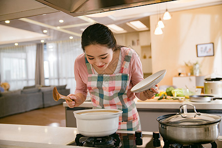 青年女人在厨房煲汤图片