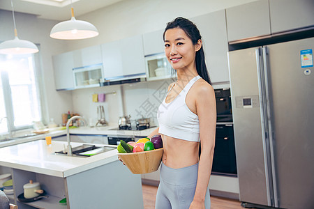 穿着运动装的青年女人在厨房图片