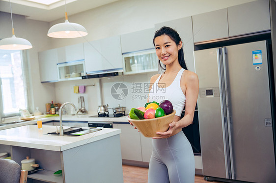 穿着运动装的青年女人在厨房图片