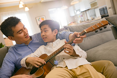 父亲和男孩在弹吉他图片