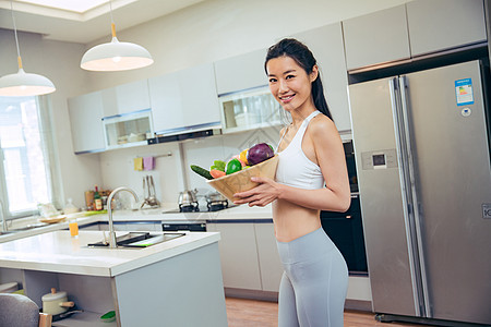 穿着运动装的青年女人在厨房图片