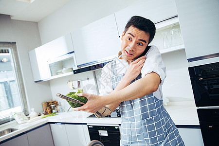 青年男人在厨房打电话图片