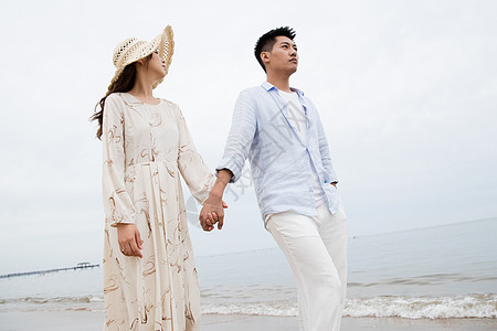 浪漫的青年夫妇在海边散步图片