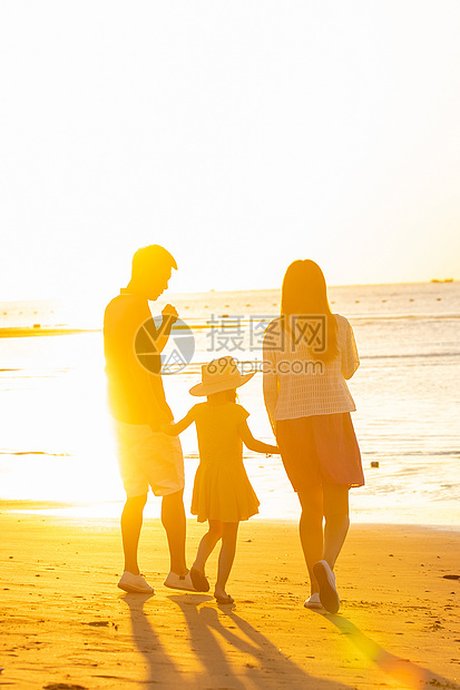 夕阳下一家三口在海边玩耍图片