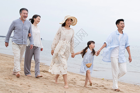 一家人在沙滩快乐的一家人在海滩上散步背景