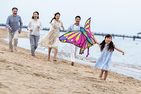 快乐的一家人在海滩上放风筝图片