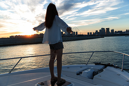 夕阳下在海边的青年女人图片